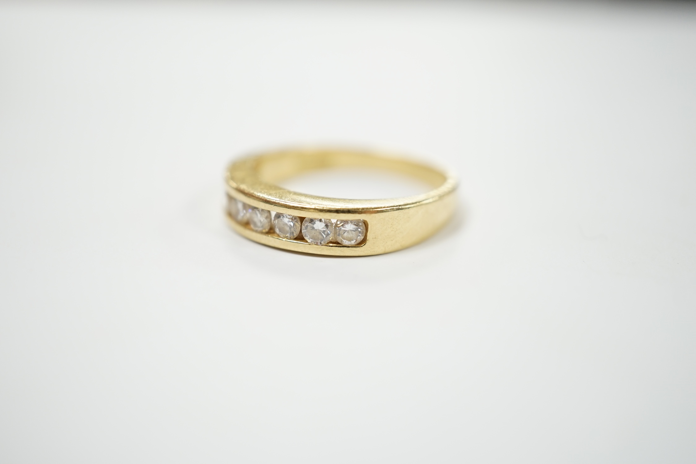 A modern 18ct gold and seven stone channel set diamond half hoop ring, size O, 5.2 grams. Condition - fair to good